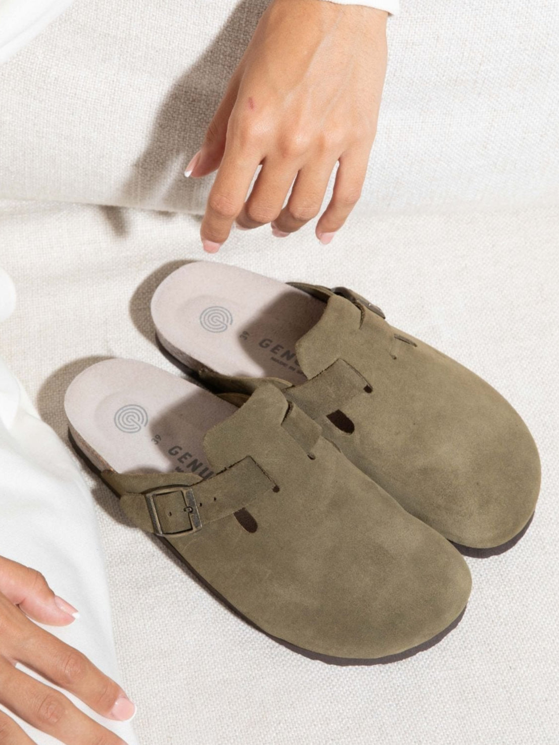 Zueco Genuins Riva de piel serraje color kaki con planta anatómica de corcho y hebilla ajustable metálica, bodegón 